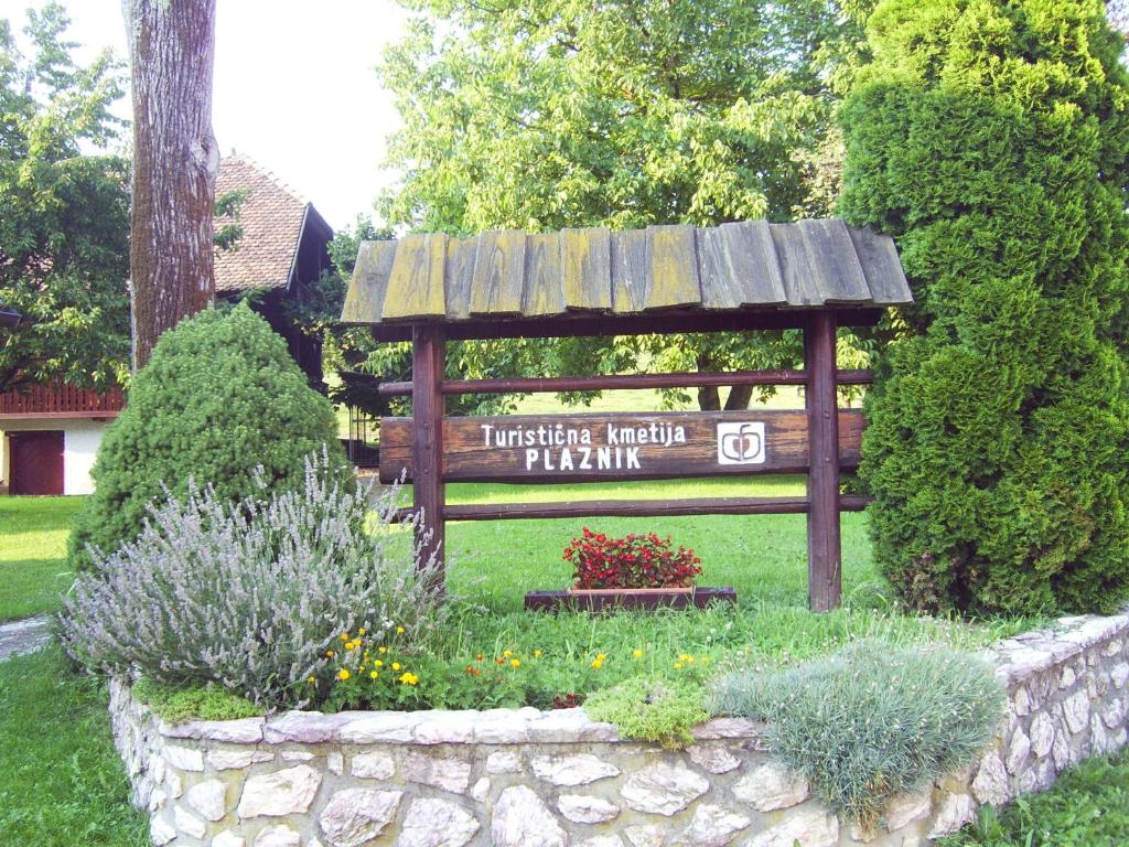 eine Parkbank mit einem Schild im Garten in der Unterkunft Guest House Turistična kmetija Plaznik in Ljubno