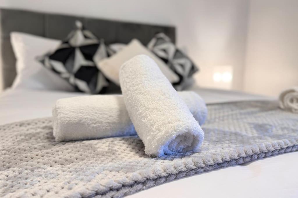 a pile of towels on top of a bed at New King-size bed en-suit, luxury refurbished home in Newark-on-Trent