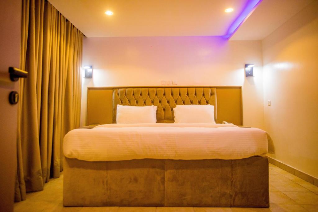 sypialnia z dużym łóżkiem z białą pościelą w obiekcie WELLINGTON HOTEL LIMITED w mieście Effurun