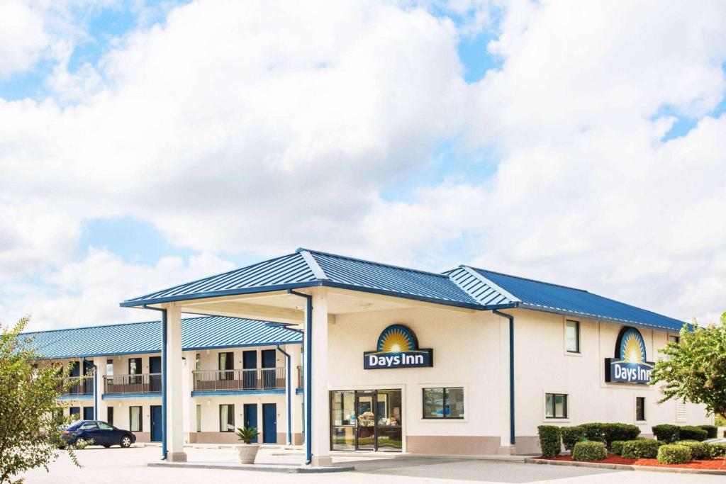 a view of a building with a blue roof at Days Inn by Wyndham Valdosta I-75 in Valdosta