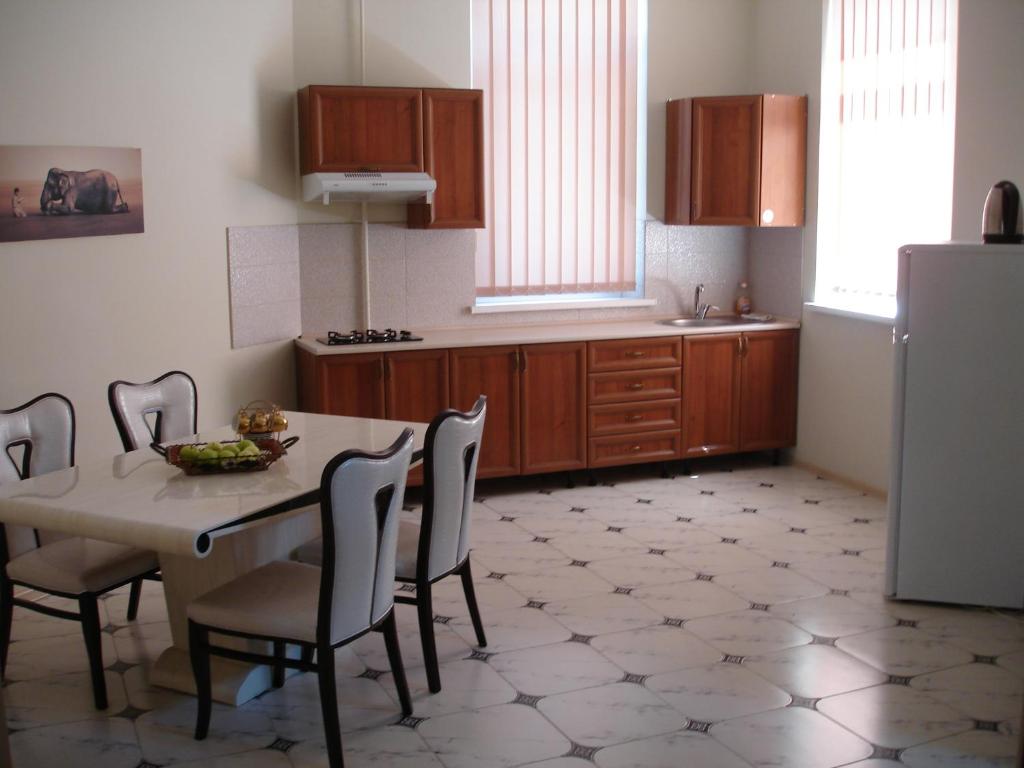 eine Küche mit einem Tisch und Stühlen sowie einem Kühlschrank in der Unterkunft Chernivtsi Apartments in Czernowitz