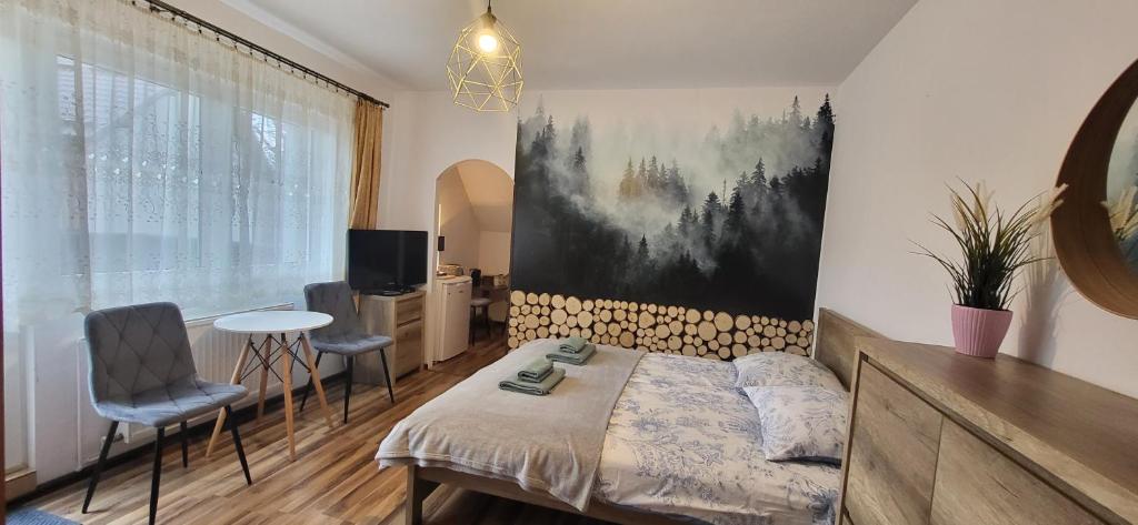 1 dormitorio con 1 cama, mesa y sillas en Pokoje Gościnne u Zosi, en Karpacz