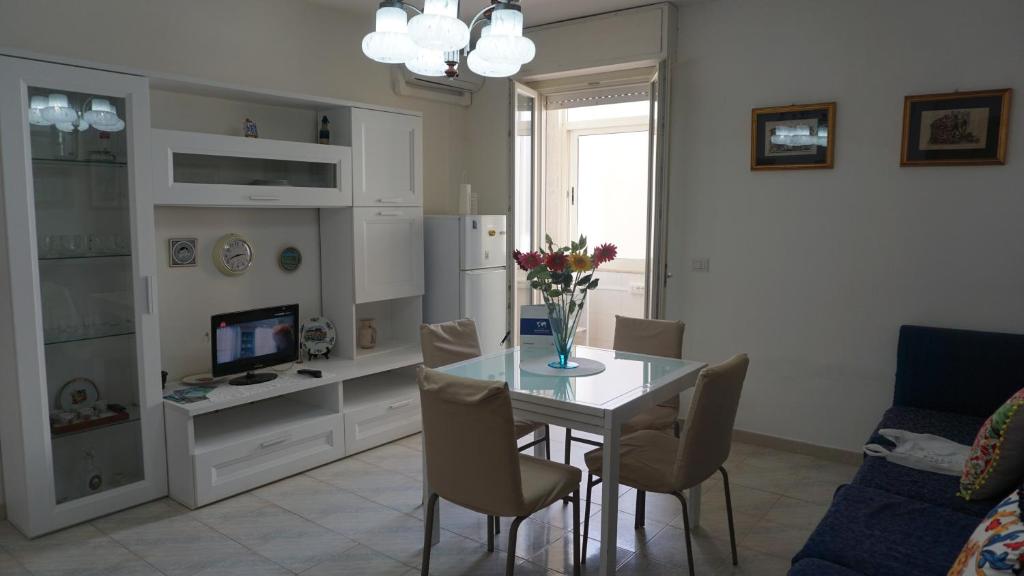 a living room with a dining room table with chairs at Appartamento Sanaccara by Holiday World in Alghero