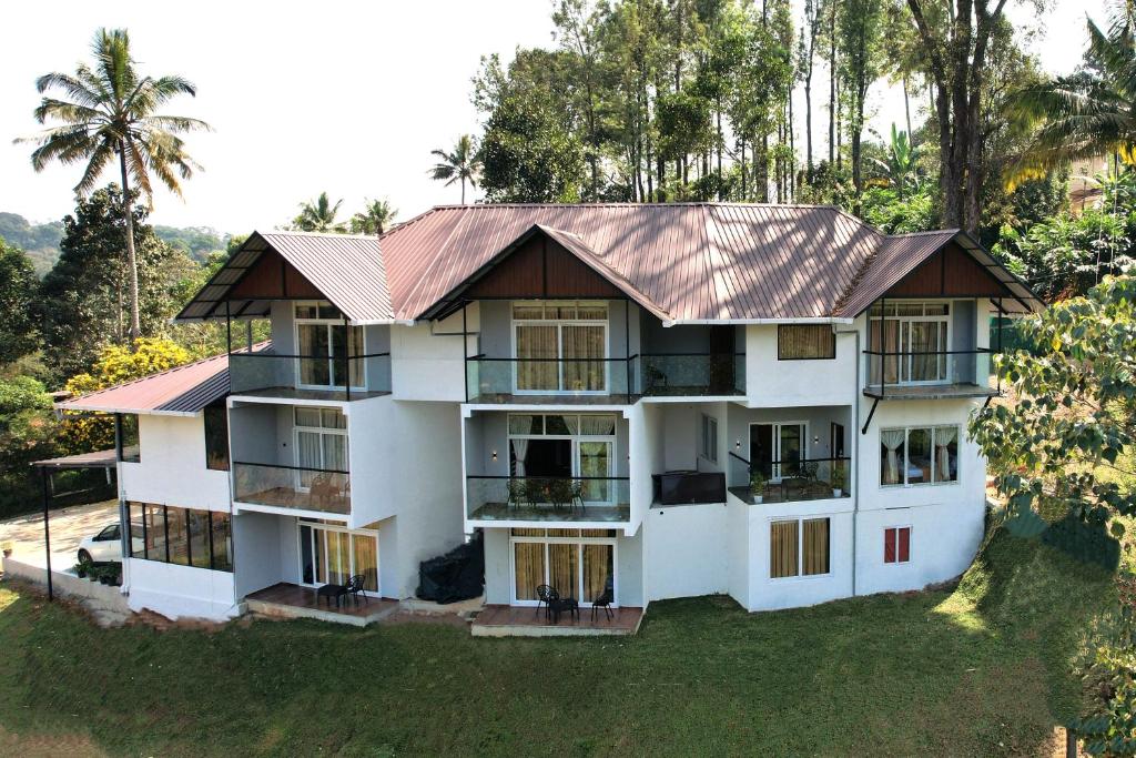 a large white building with a metal roof at Elenji Revive Resort in Munnar