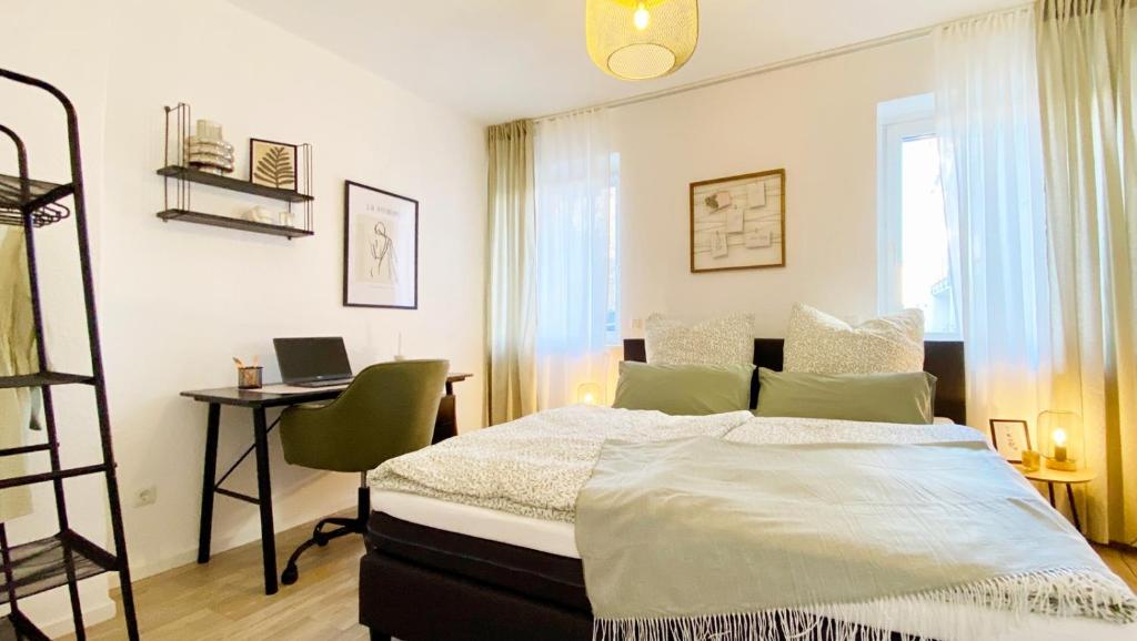 a bedroom with a bed and a desk with a laptop at Bloßfeld-Apartments Geräumige Stadtoase mitten im Zentrum mit 3 Schlafzimmern, Gratis Parkplatz, W-Lan, Netflix in Jena