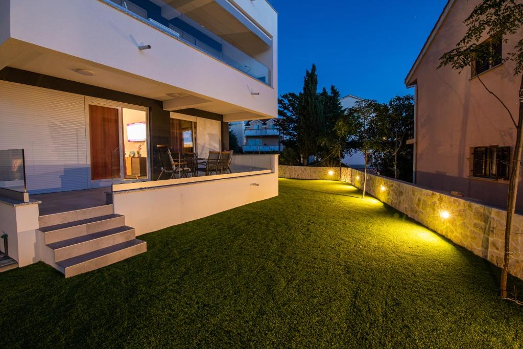 a house with lights on the yard at night at Luxury Apartment Marija in Novalja
