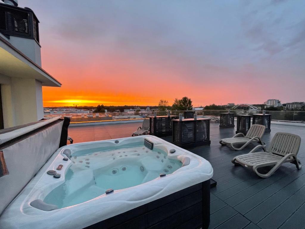 einen Whirlpool auf einem Balkon mit Blick auf den Sonnenuntergang in der Unterkunft Apartamenty Polanowscy Baltic Marina Residence z mini SPA przy Bałtyckiej in Kołobrzeg