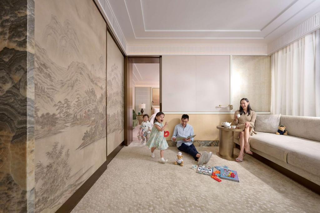 a woman and three children sitting in a living room at Island Shangri-La, Hong Kong in Hong Kong