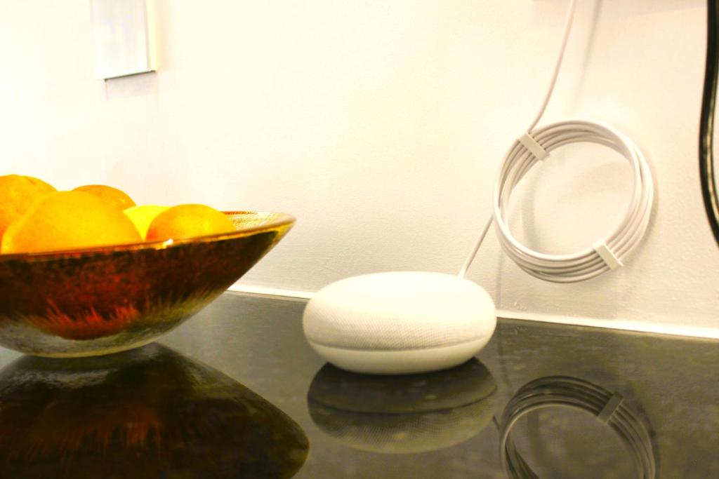 eine Schüssel Orangen auf einem Tisch neben einem Spiegel in der Unterkunft G 0.9 - G.oogle Nest Smart House in Braga