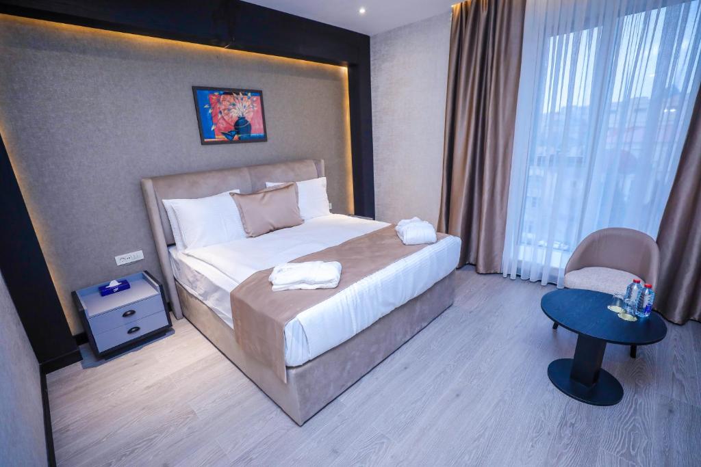 Arium Hotel Baku في باكو: غرفه فندقيه بسرير وكرسي