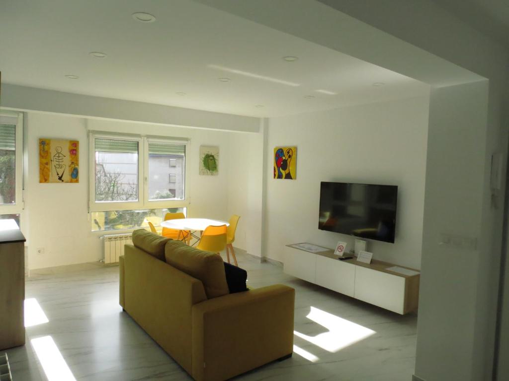 Apartamento JARDIN DELUZ, con Wifi y Parking privado gratis في سانتاندير: غرفة معيشة بها أريكة وتلفزيون