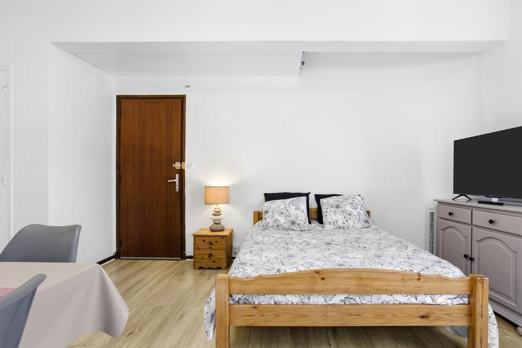 a bedroom with a bed and a flat screen tv at Fréjus Base Nature in Fréjus
