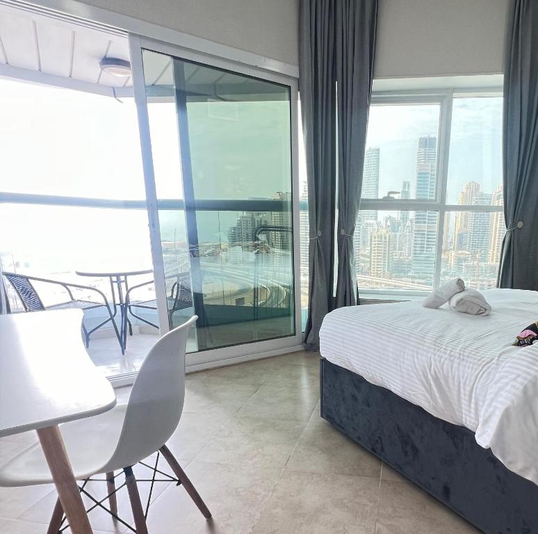 a bedroom with a bed and a balcony with a view at Jumeirah lake towers in Dubai
