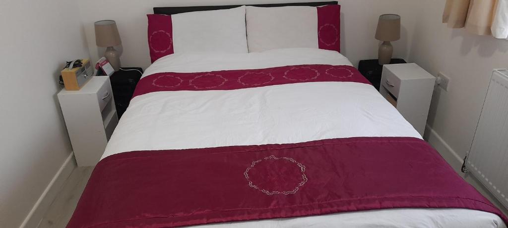 a bed with a red and white blanket on it at Appendix 254 in Oldbury