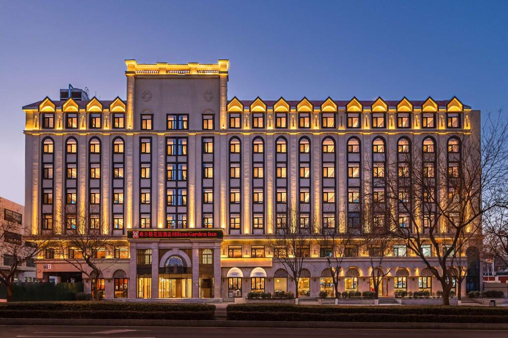 un grande edificio con luci accese di Hilton Garden Inn Beijing Temple Of Heaven East Gate Station a Pechino