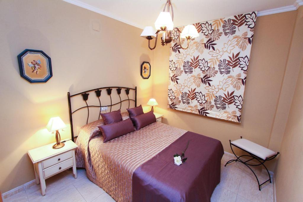 薩洛的住宿－Carlos 5 Planet Costa Dorada，一间卧室配有一张带紫色枕头的床