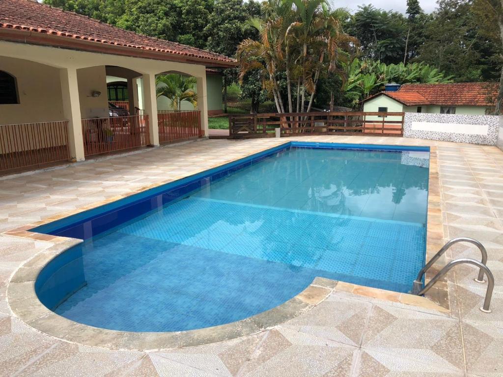 una piscina en un patio con una casa en Sitio en Pinhalzinho