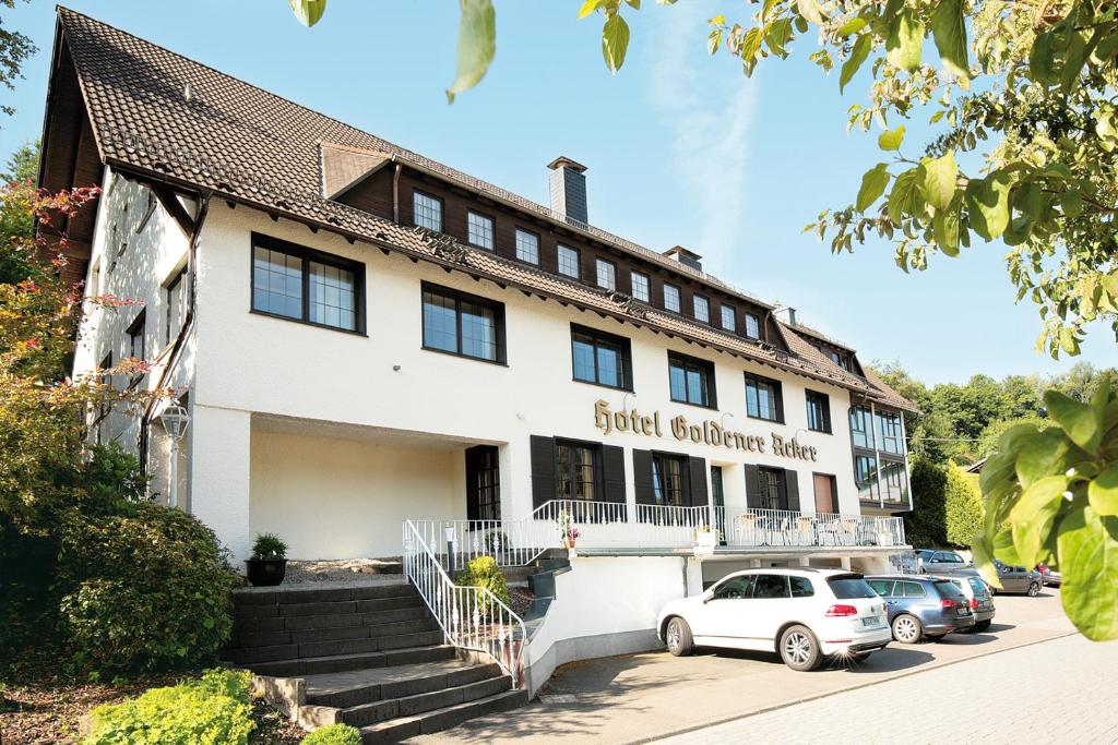 ein Gebäude mit davor geparkt in der Unterkunft Landhotel Goldener Acker in Morsbach