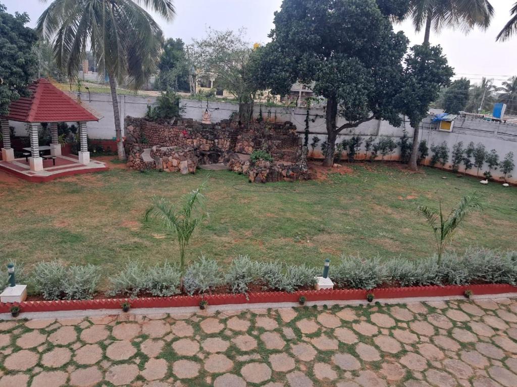un jardín con una pared de piedra y un patio con plantas en SS HOME STAY, en Bangalore