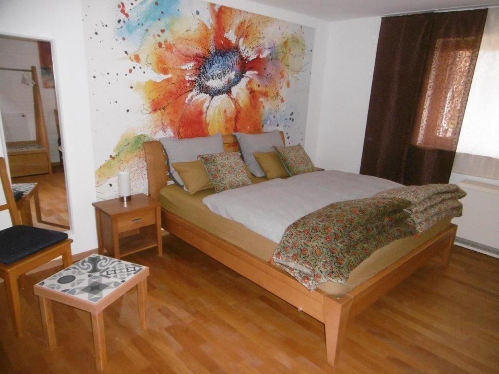 a bedroom with a bed with a painting on the wall at Mühlenwörth Relax Quartier in Tauberbischofsheim
