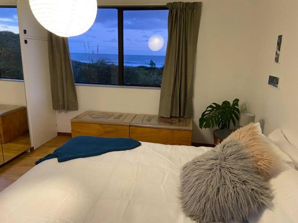 um quarto com uma cama grande e uma janela grande em Ocean Retreat em Brighton