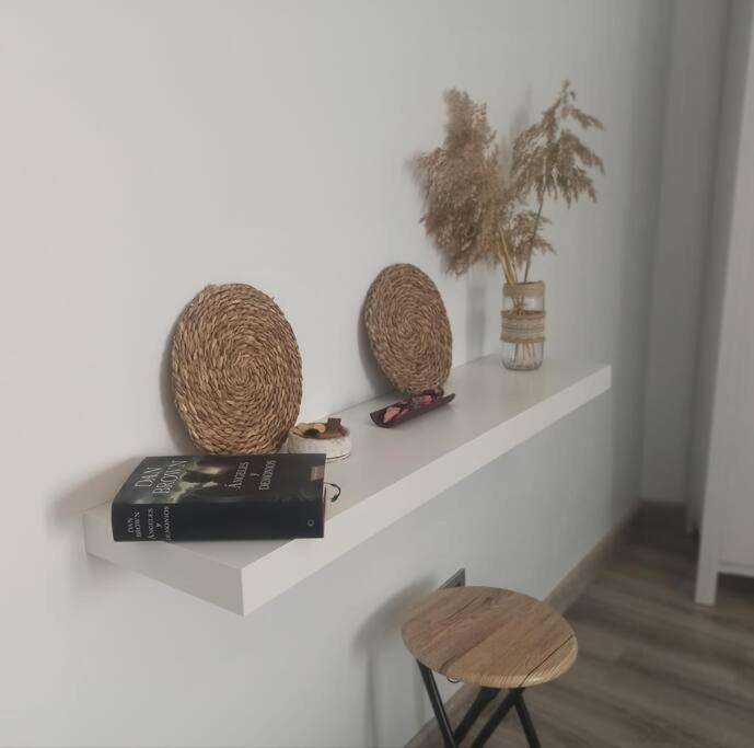 a shelf with two baskets and a book and a chair at Casa para relajarse, con vistas. in Caravaca de la Cruz