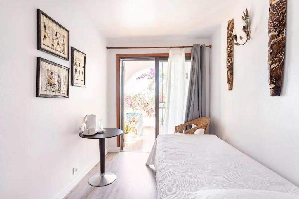 a bedroom with a bed and a table and a window at Ocean House in Granadilla de Abona