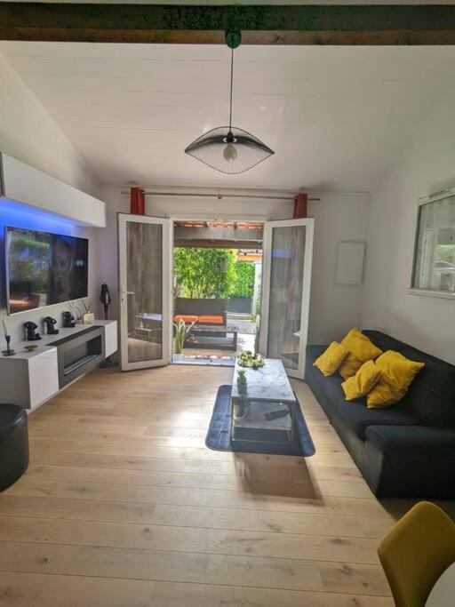 un salon avec un canapé et une télévision dans l'établissement Maison individuelle avec jardin ensoleillé, à Auribeau-sur-Siagne