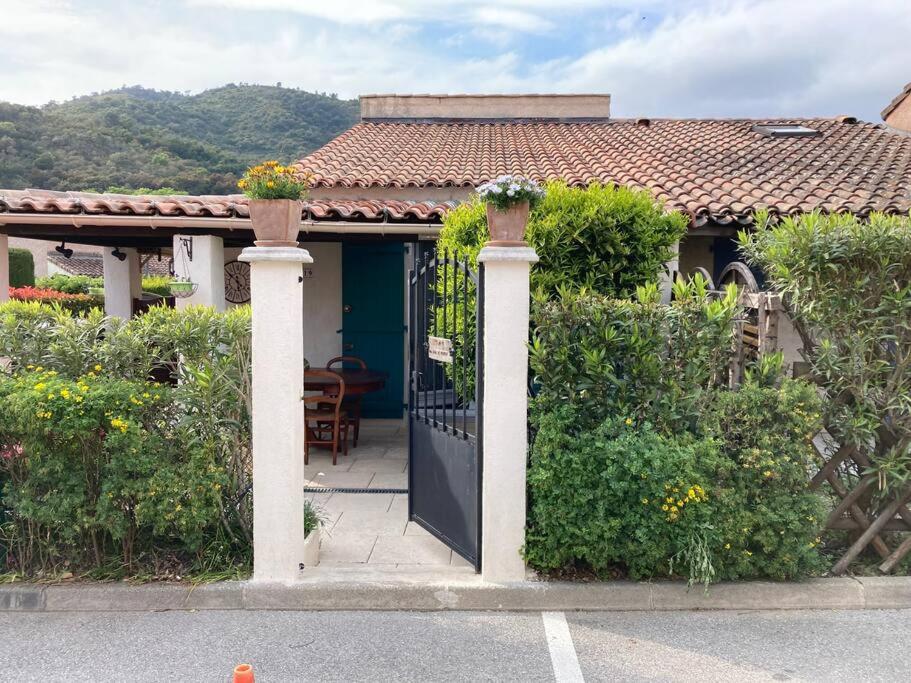 ein Haus mit einer schwarzen Tür und einem Zaun in der Unterkunft Maison individuelle avec jardin ensoleillé in Auribeau-sur-Siagne