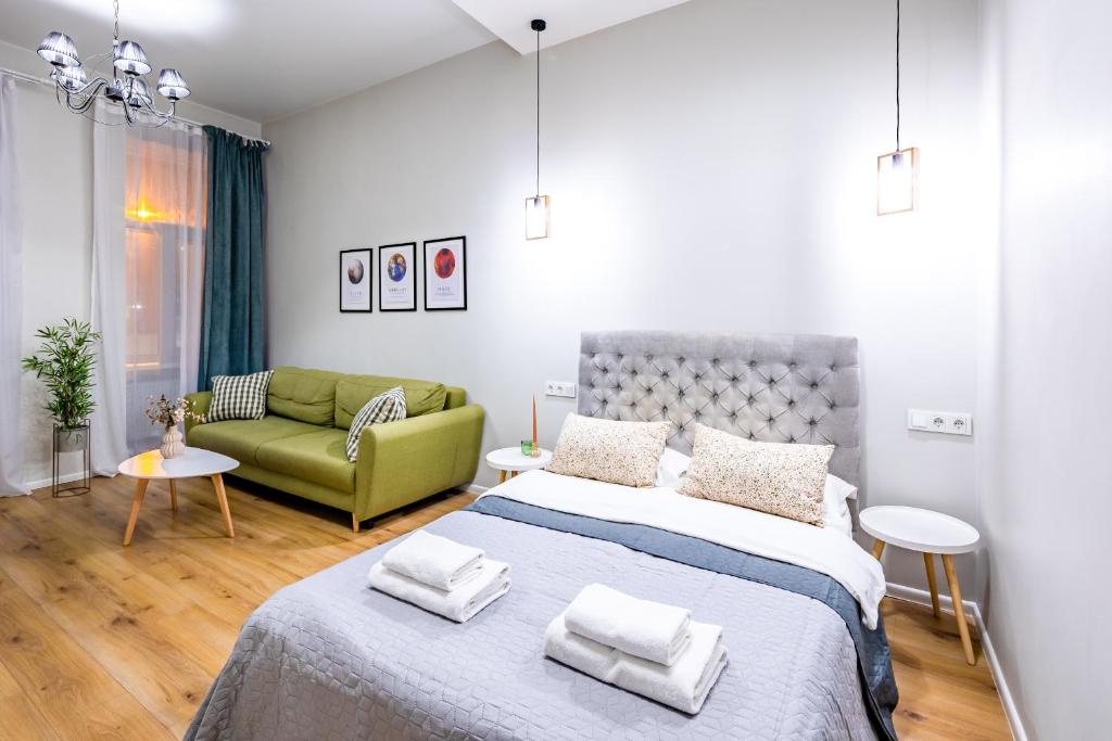 a bedroom with a bed and a green couch at Your sweet home in Lviv Near Opera in Lviv