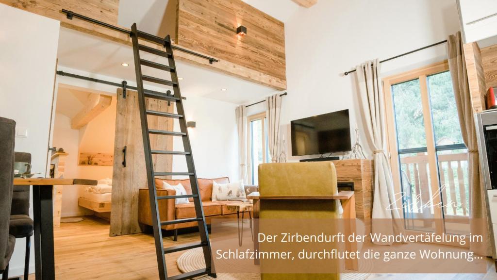 a ladder in a room with a living room at Zirben -Chalet 2 in Winkl Heiligenblut