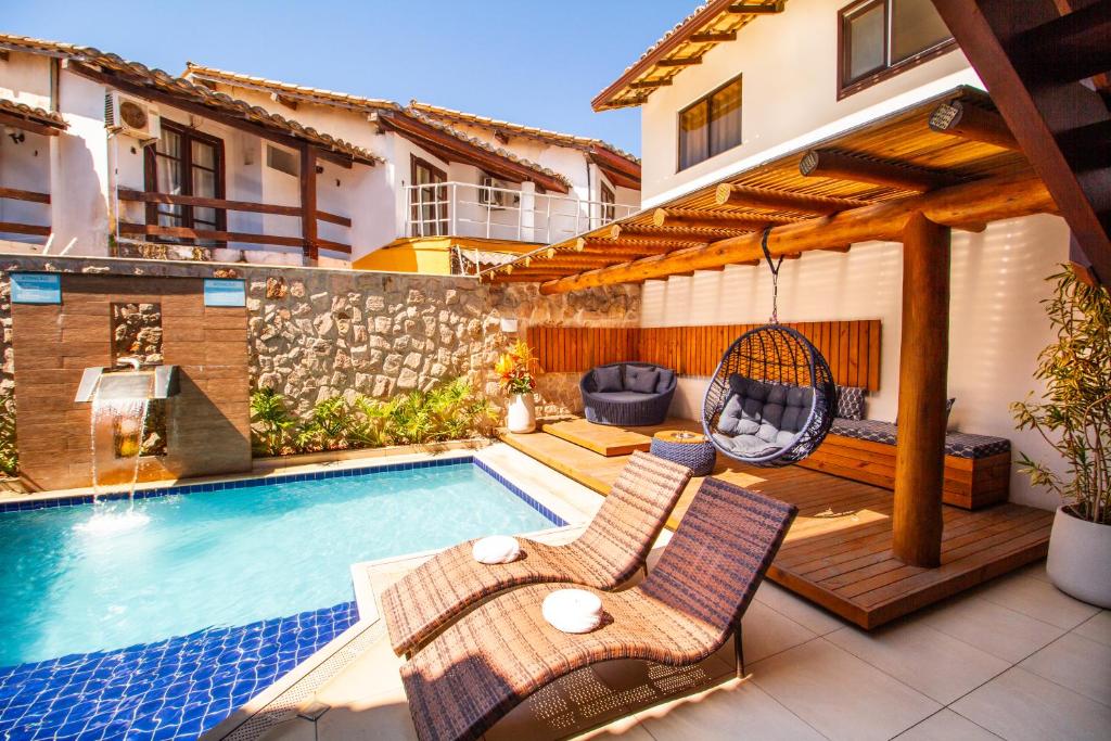 a patio with a swing and a swimming pool at Hotel Bem Brasil in Porto Seguro