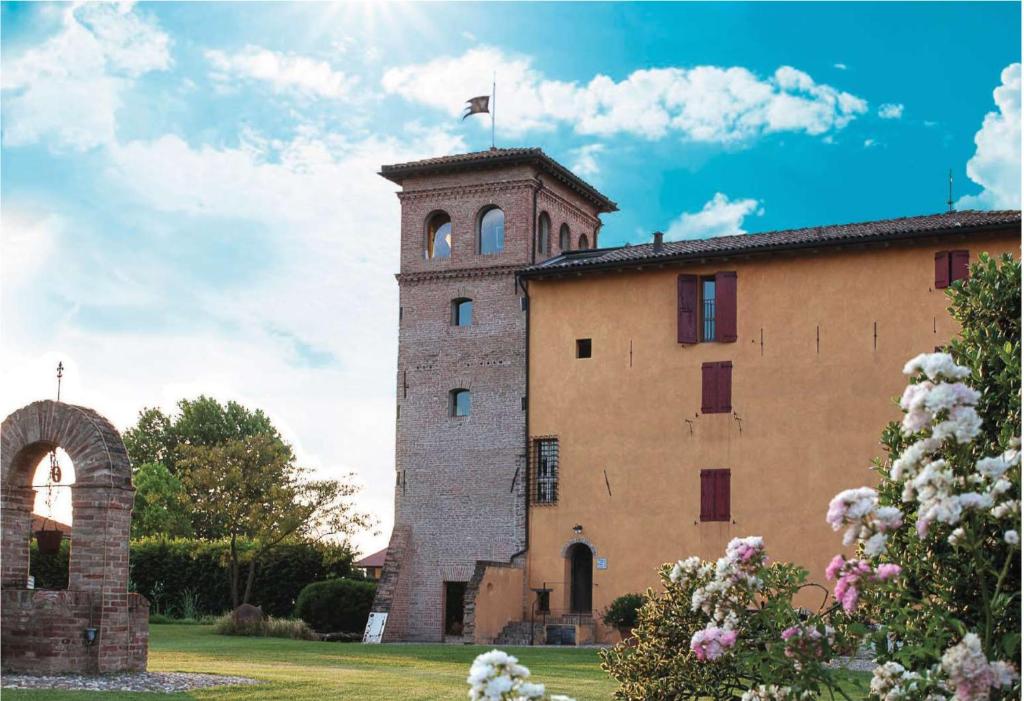 um edifício com uma torre com uma bandeira em cima em Palazzo delle Biscie - Old Tower & Village em Molinella