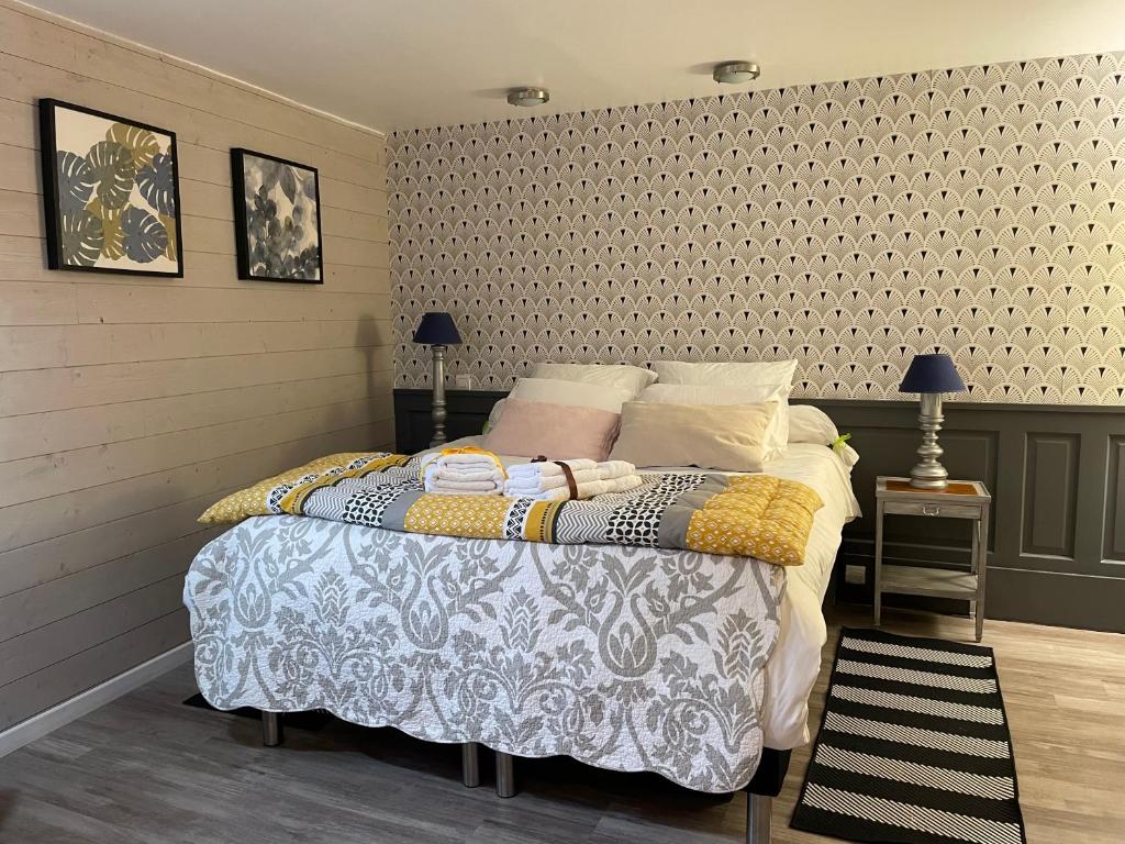 a bedroom with a bed and two tables and a wall at La Maison Bizienne Guérande in Guérande