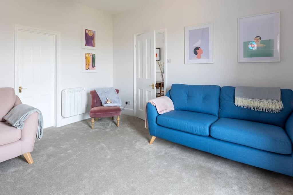 sala de estar con sofá azul y silla en Large two bedroom Apartment in Cliftonville, en Kent