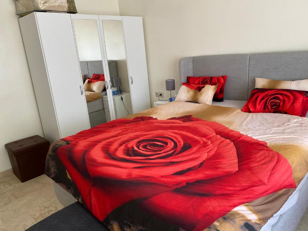 a bedroom with a bed with a red rose on it at Apartement Marina Zina, Agadir in Agadir