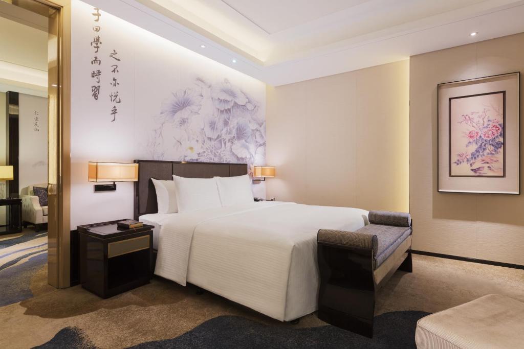 Giường trong phòng chung tại Wanda Realm Jining