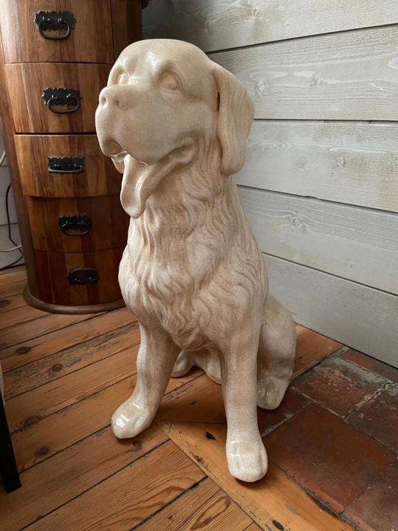 a statue of a white dog sitting on the floor at La Maison Bizienne Guérande in Guérande