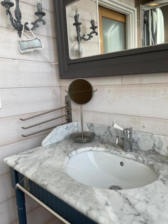 a bathroom with a marble sink and a mirror at La Maison Bizienne Guérande in Guérande