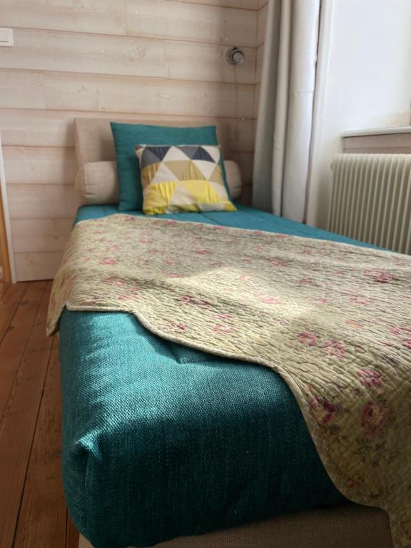 a bed with a blue comforter in a room at La Maison Bizienne Guérande in Guérande