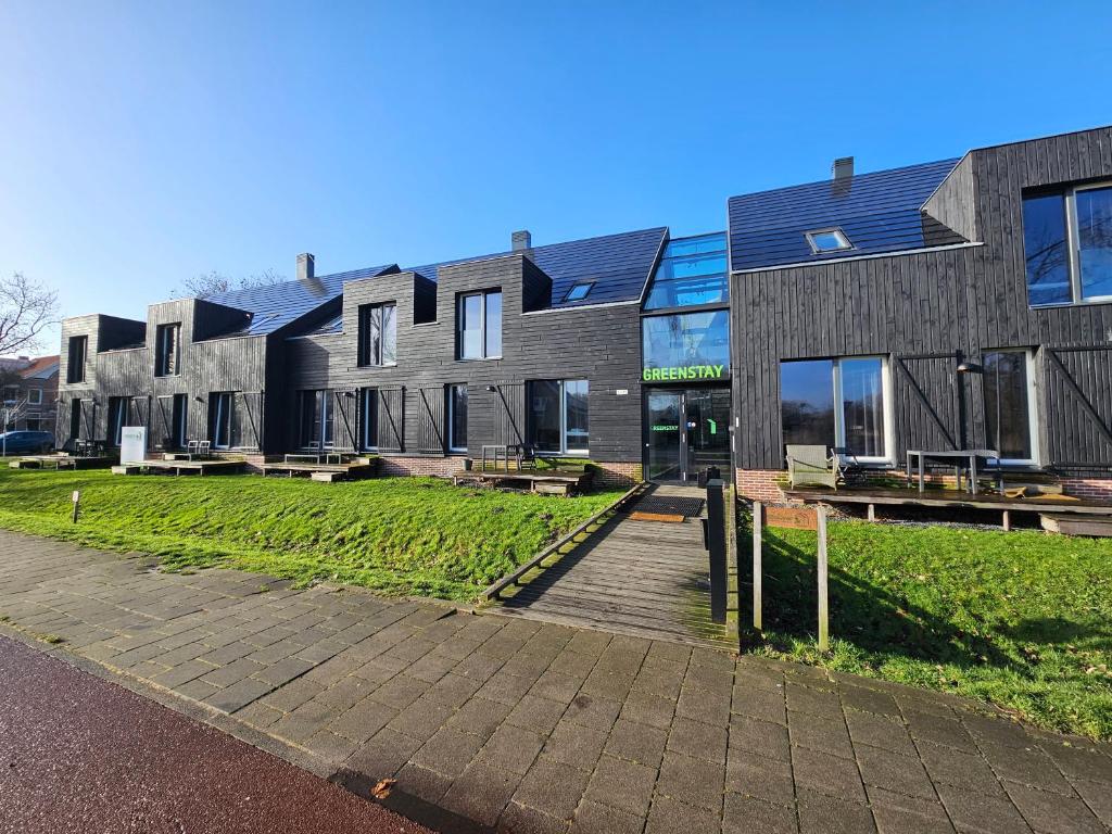 阿姆斯特丹的住宿－Greenstay，一座建筑,前方设有庭院和长椅