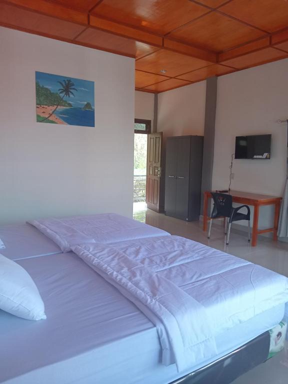 um quarto com uma cama grande e uma secretária em Matraville guesthouse em Tuktuk Siadong