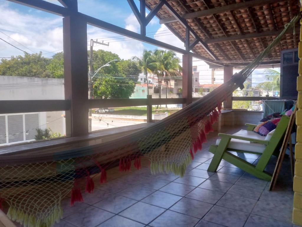 a hammock in a porch with a view of a street at Hostel Porto Vip in Porto De Galinhas