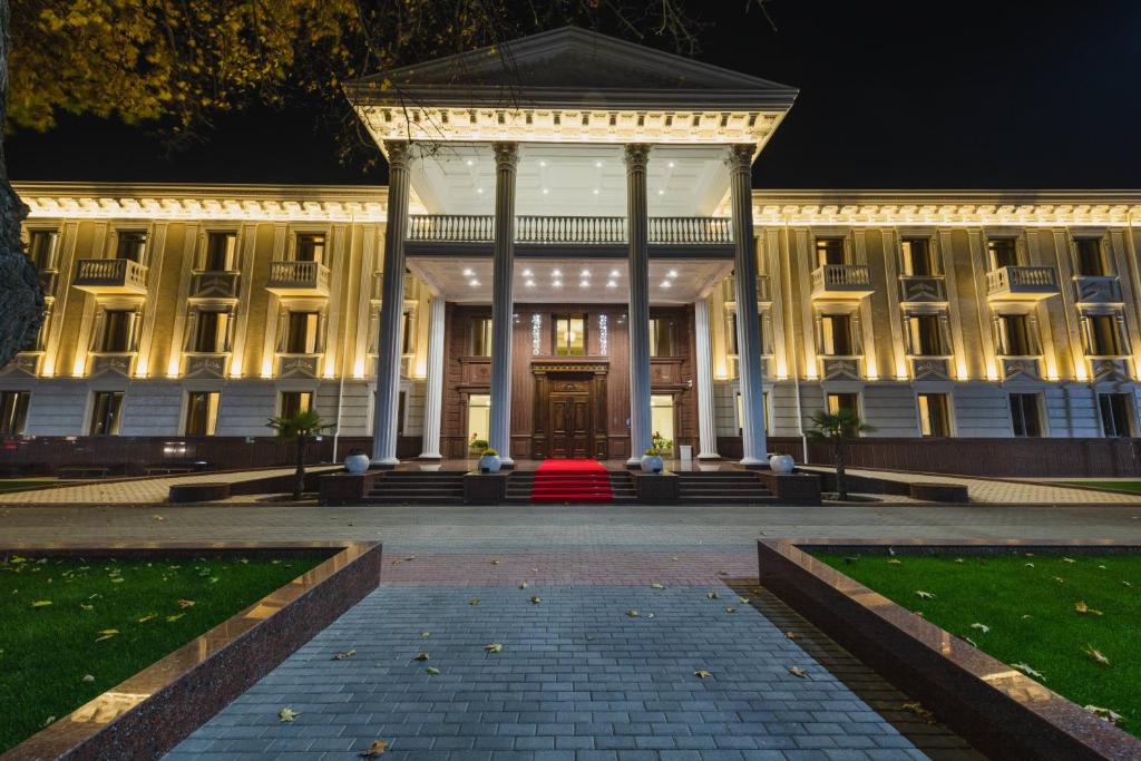 un gran edificio blanco con una gran puerta delantera por la noche en Zarafshon Parkside, en Samarkand