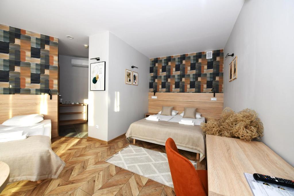 ジェシュフにあるHotel Poloniaのベッドルーム1室(ベッド2台、テーブル、椅子付)