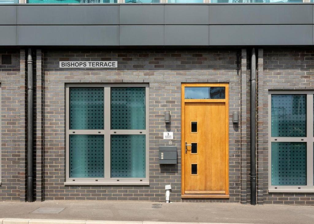 a wooden door on the side of a brick building at Castle Haven Apartment Redhill in Redhill