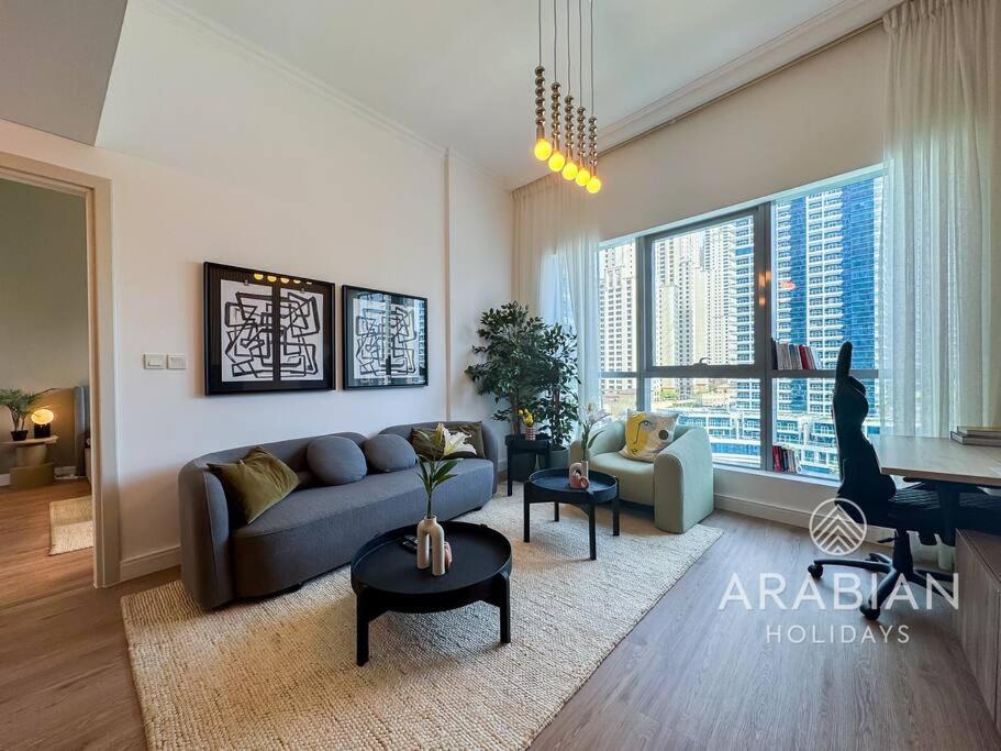 a living room with a couch and a table at Exclusive Newly Renovated 1BR full Marina views in Dubai