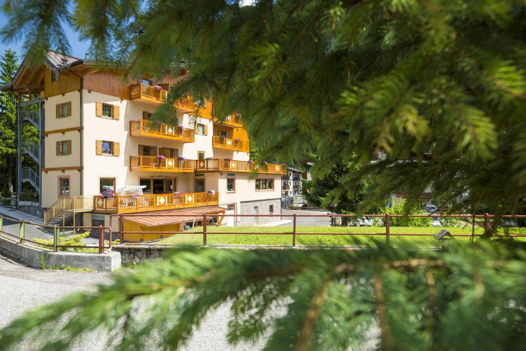a large white building with a balcony in front of it at Relais San Giusto in Campitello di Fassa