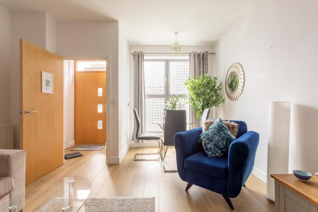 a living room with a blue chair and a table at Queens Lodge 1-Bed Apartment in Redhill in Redhill