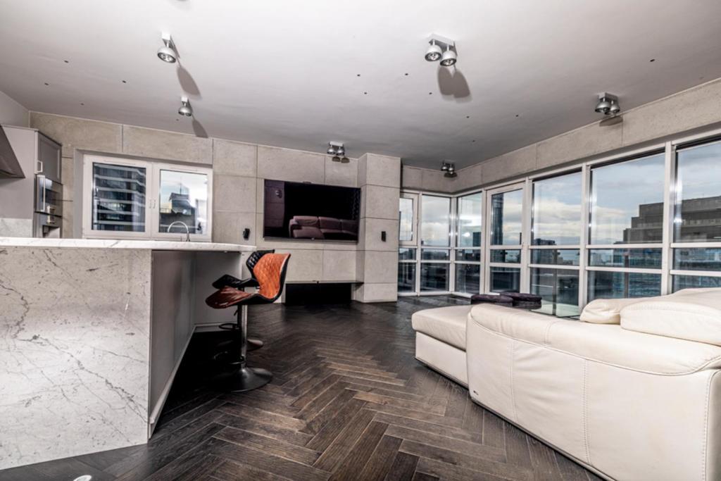 uma sala de estar com um sofá branco e um balcão em Black Pearl - Amazing City View, 130 sqm em Varósvia